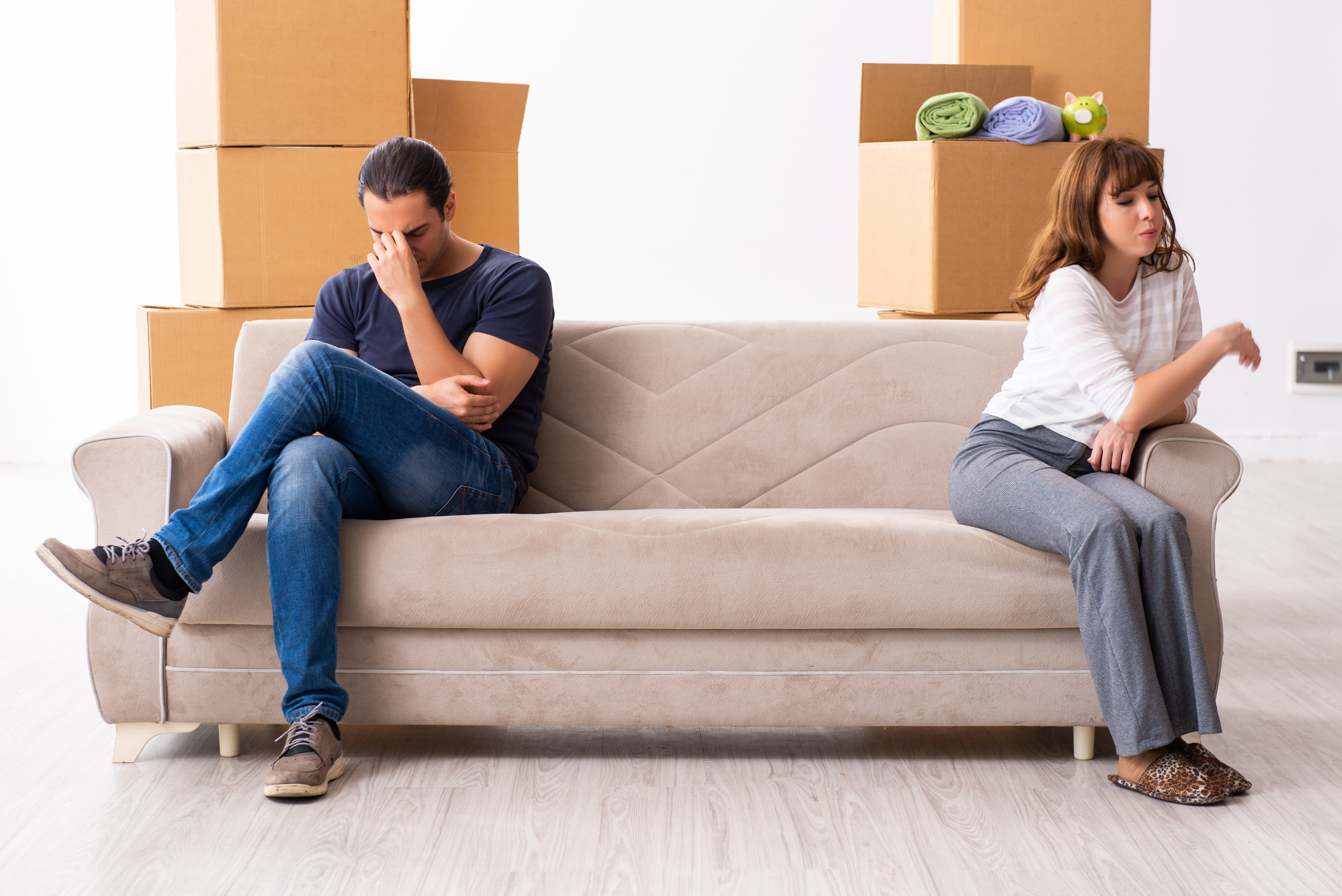 paar sitzt auf der couch mit kartons, immobilien news-artikel