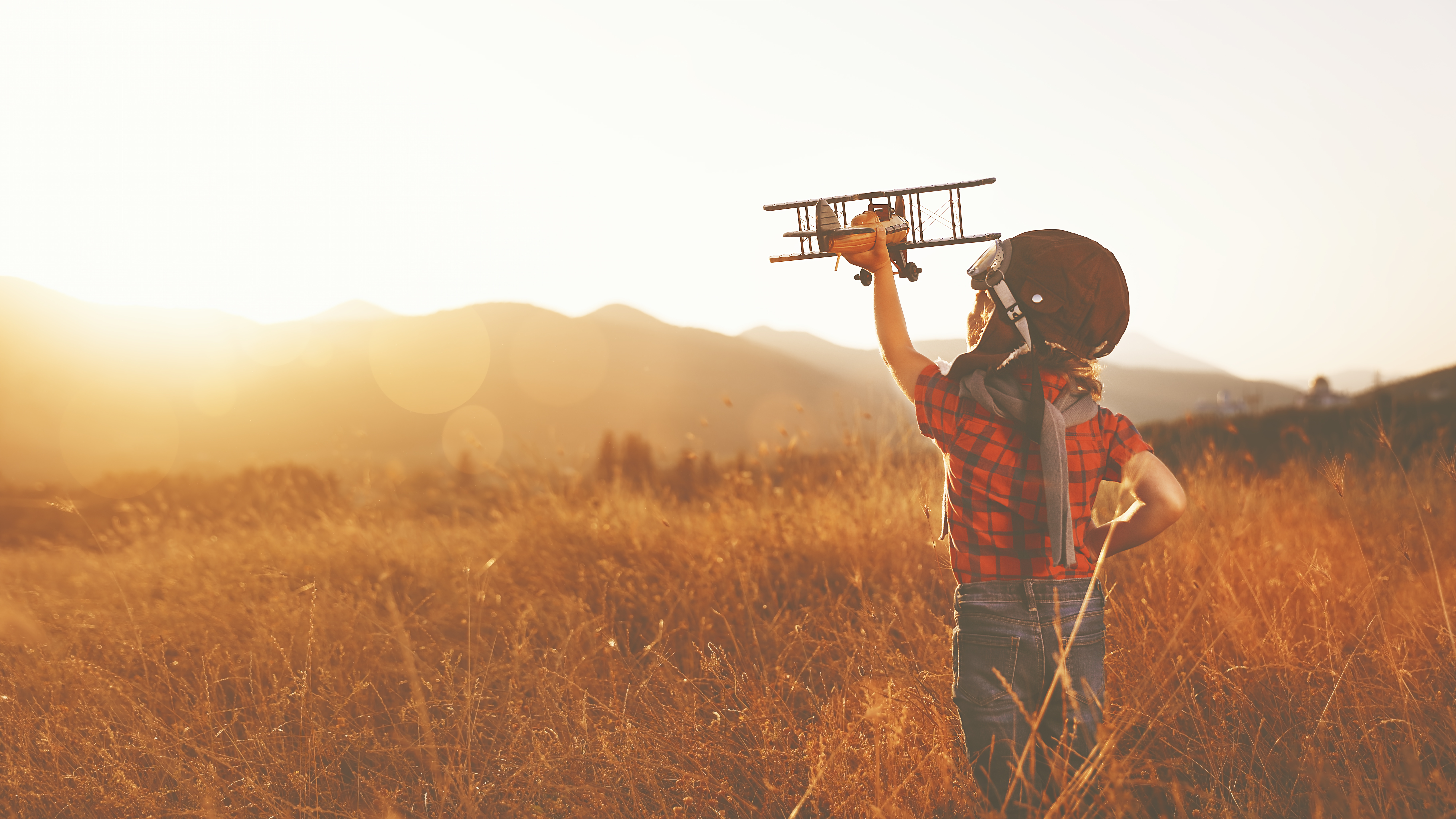 kind hält flugzeug hoch. soll das flugzeugleasing darstellen