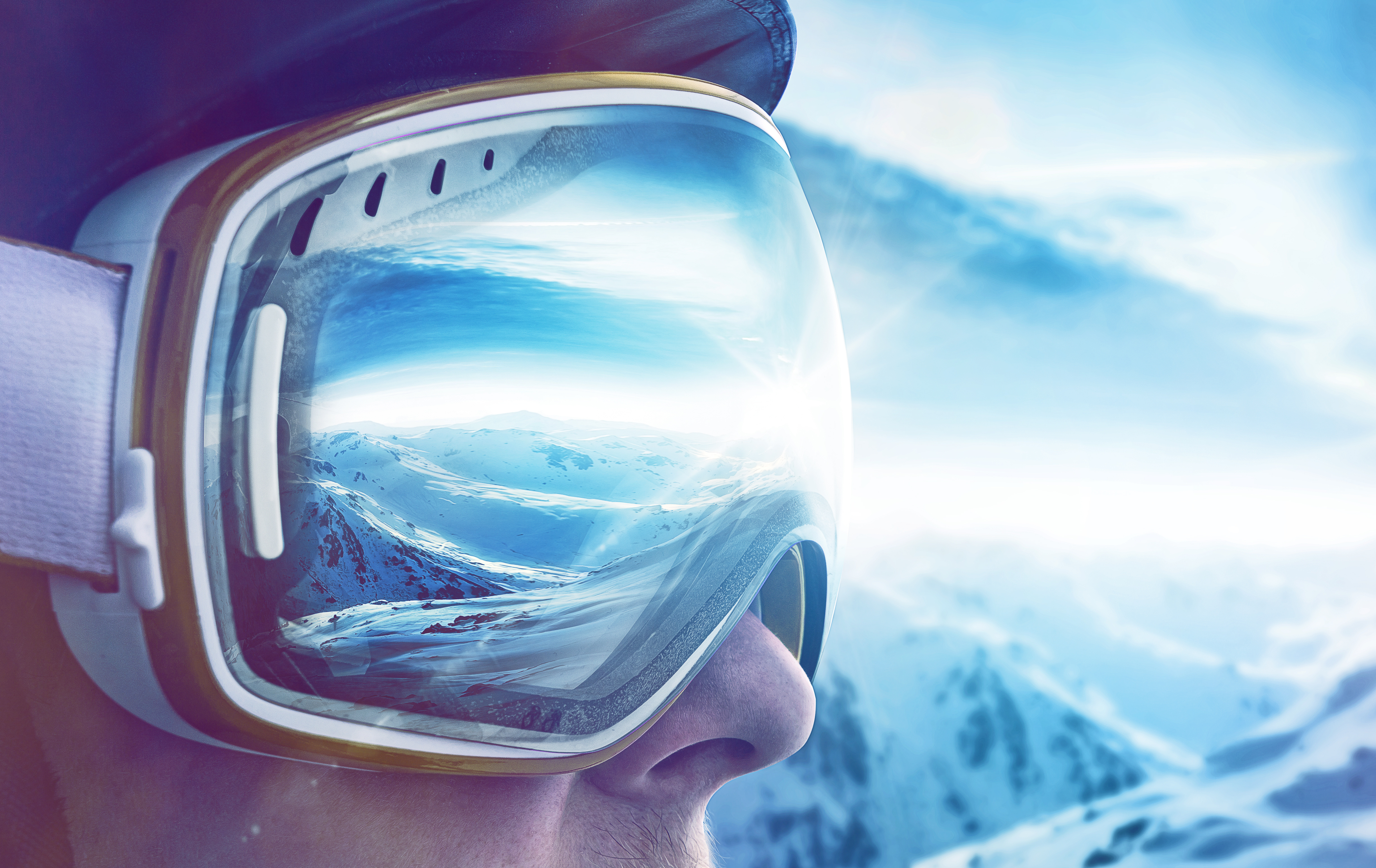 Frau mit Skibrille sieht auf Skigebiet