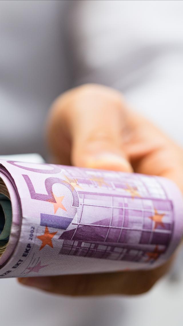 hand hält geld für einen leasing news-artikel