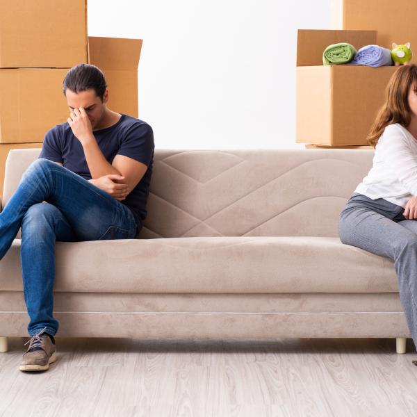 paar sitzt auf der couch mit kartons, immobilien news-artikel