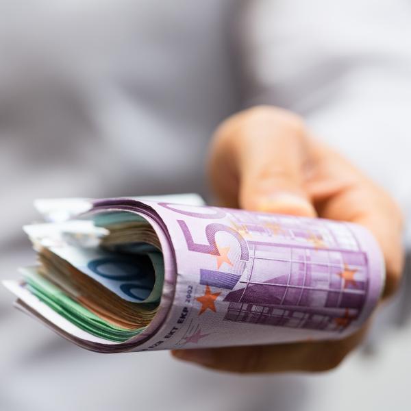 hand hält geld für einen leasing news-artikel