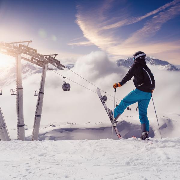 Skifahrer steht vor einer geleasten Seilbahn der Hypo Immobilien und Leasing